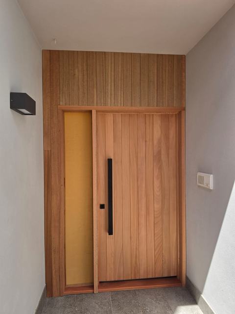 Timber front door with timber panel above