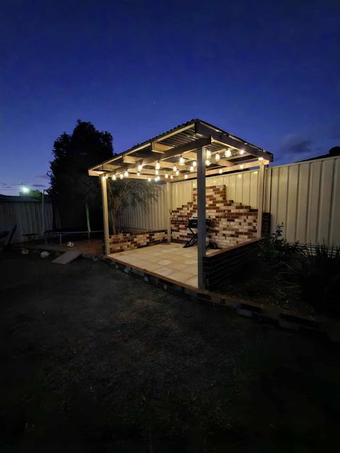 Timber pergola with festoon lights at dusk