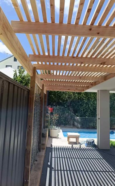 Slatted timber pergola beside a pool